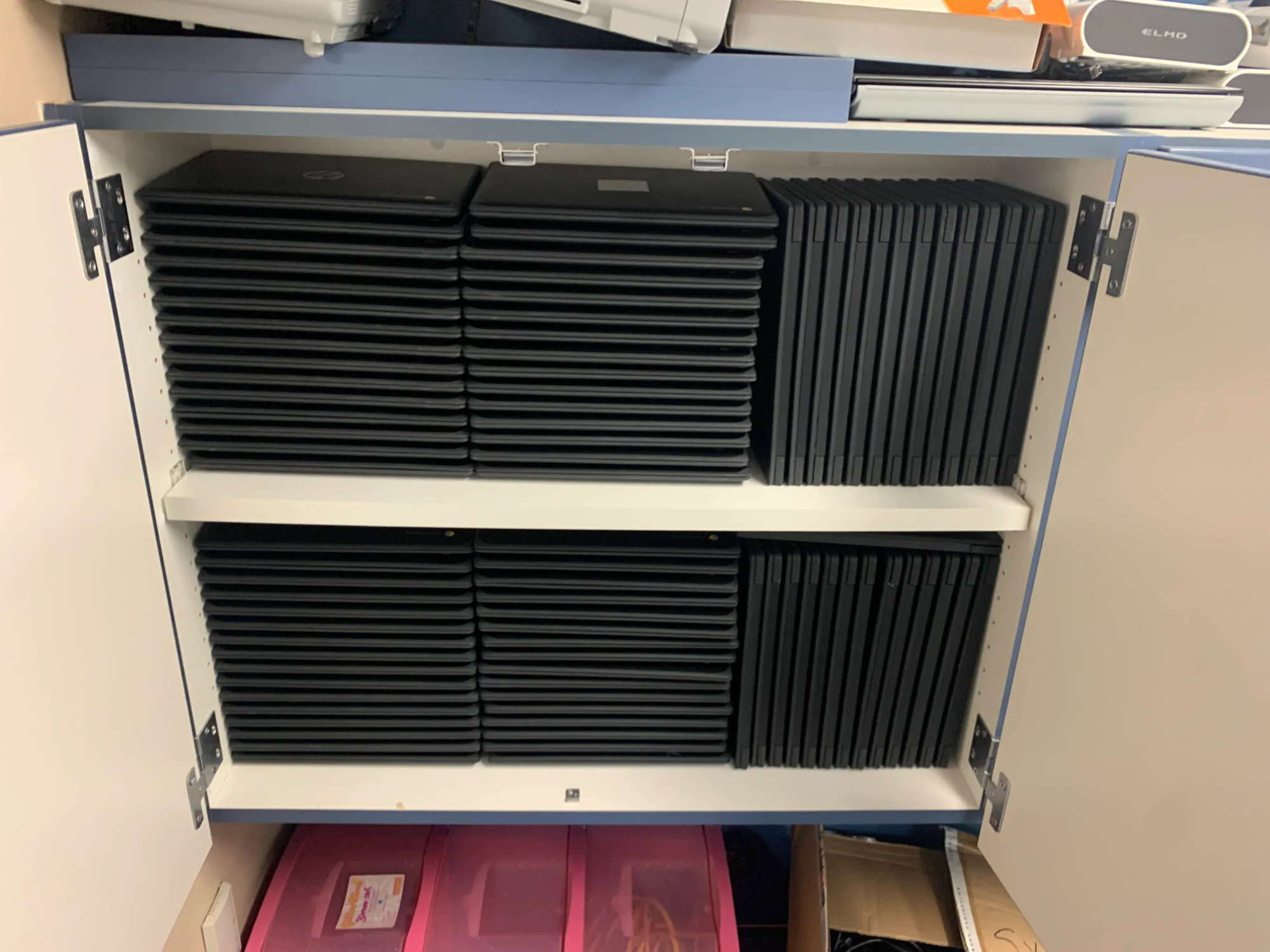 Cabinet full of organized Chromebook laptops